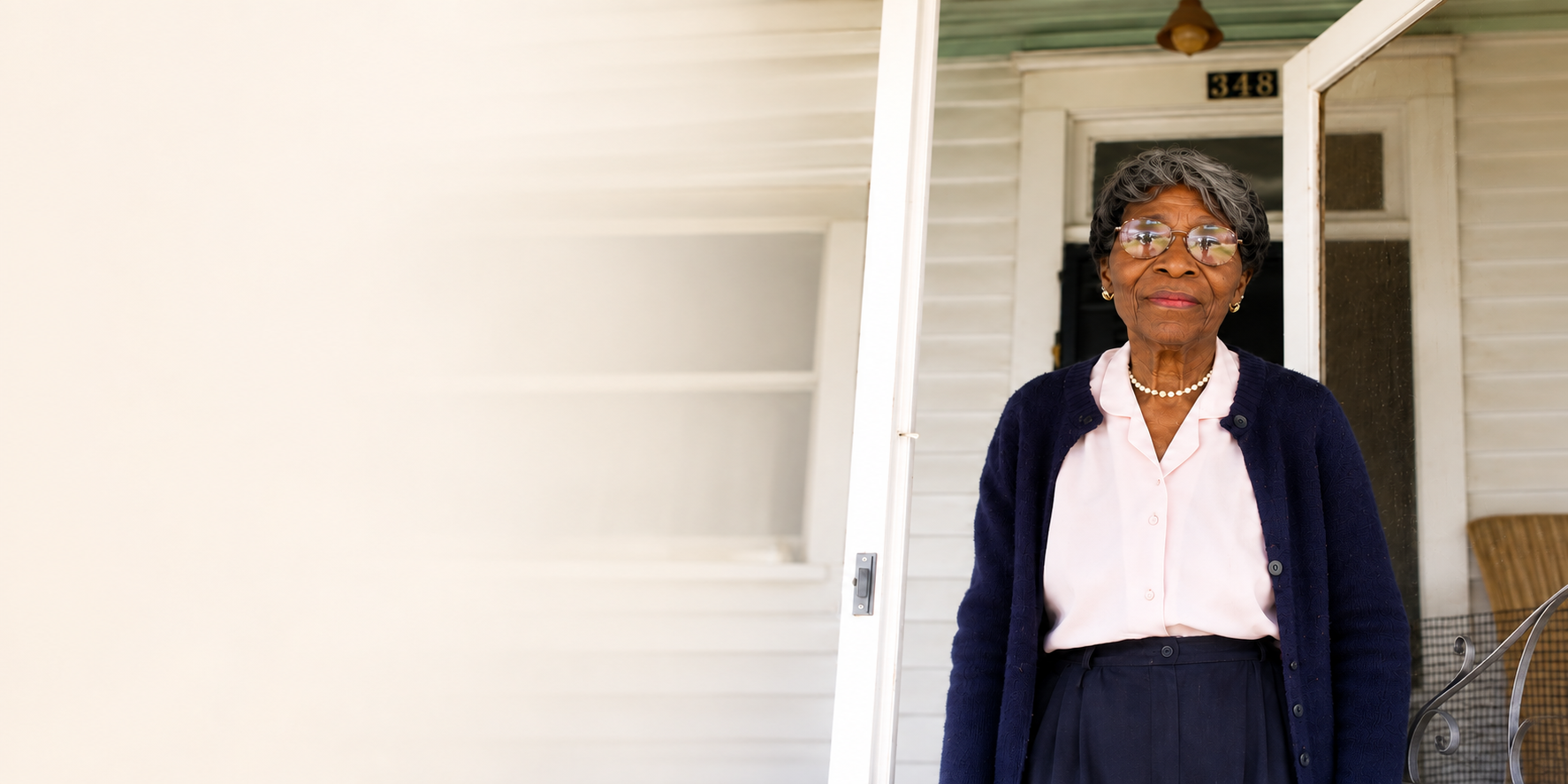Miss Verlie White, an elderly woman, on her welcoming porch